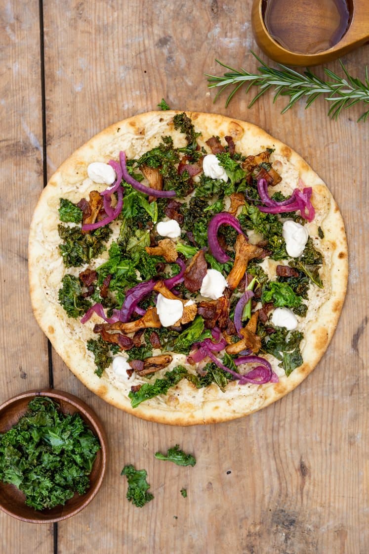 Pizza bianco - pizza, jossa ranskankermaa, voissa paistettuja kantarelleja, pekonia ja pikkelöityä punasipulia