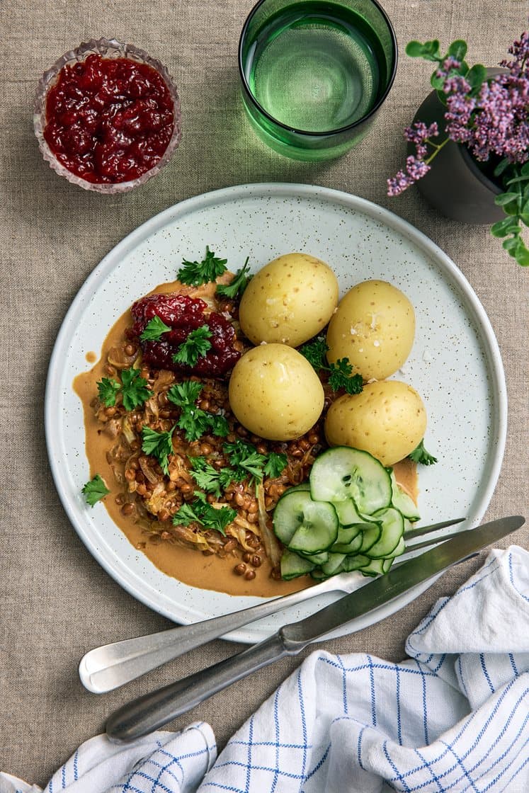 Kaali- ja linssipannu keitettyjen perunoiden, puolukkahillon ja persiljan kanssa