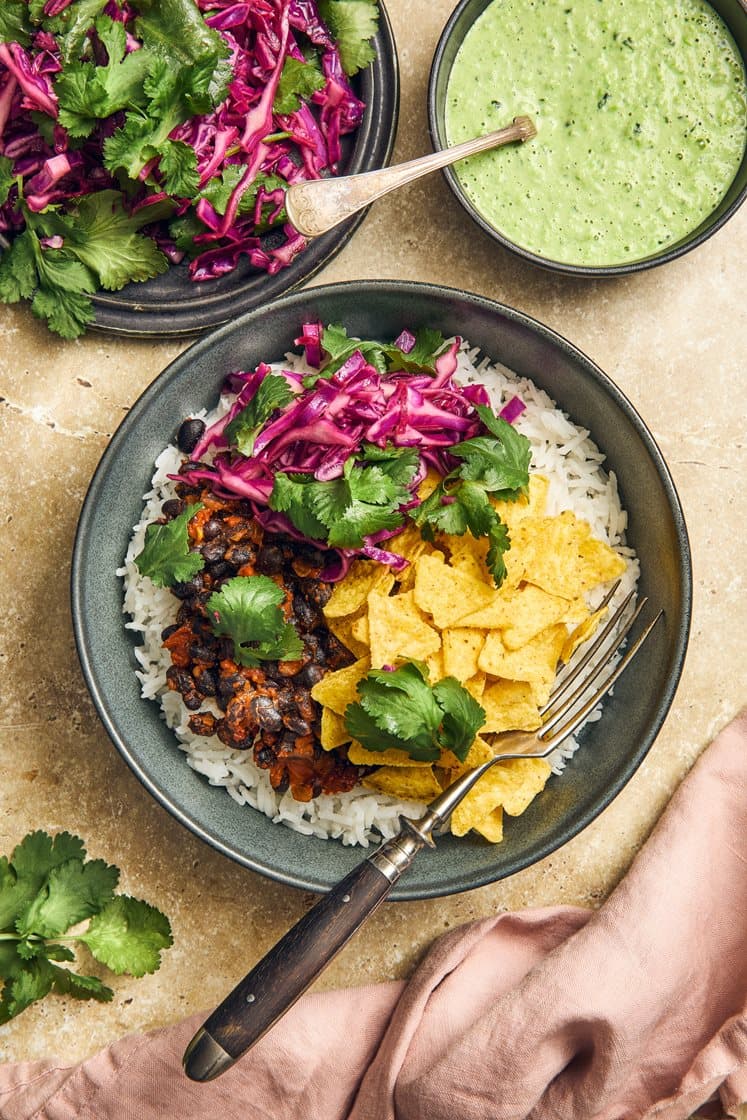 Latinalaisamerikkalainen nachobowl refried beansin ja hernemolen kanssa
