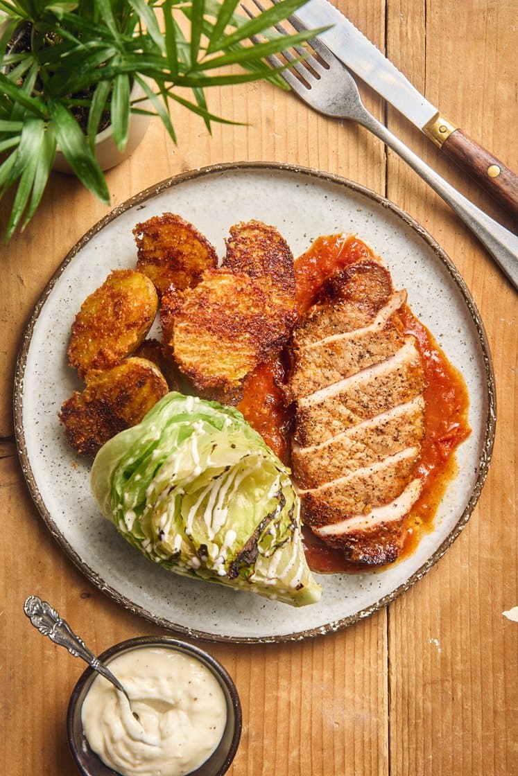 Porsaankyljys tomaattikastikkeessa aiolin, parmesaaniperunoiden ja grillatun salaatin kanssa