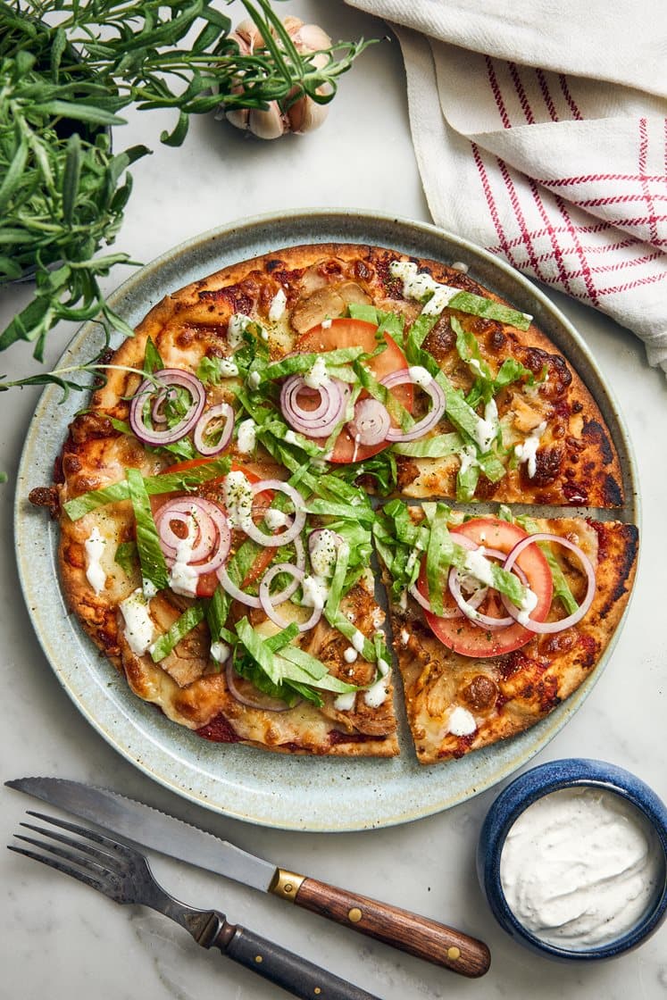 Kanakebabpizza valkosipulikastikkeella, jäävuorisalaatilla ja punasipulilla